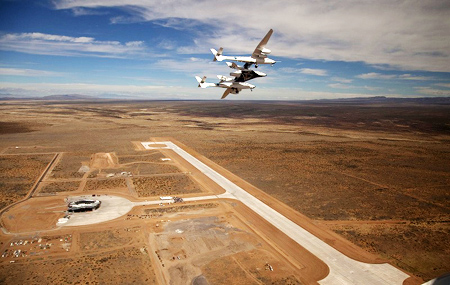 米国ニューメキシコ州の標高1,400mにある専用宇宙港「スペースポートアメリカ」の上空を試験飛行するSS2を結合したWK2。下にヴァージン・ギャラクティック社の専用ターミナルビル（「ヴァージンギャラクティック・ゲイトウェイ・ツー・スペース」）と約3,000mの滑走路が見える。（提供ヴァージン・ギャラクティック）