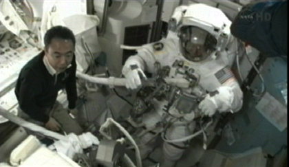 写真：EMUの装着を支援する古川宇宙飛行士