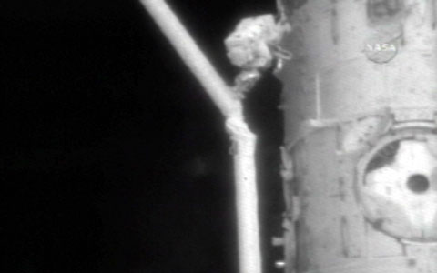 写真：スペースシャトルのロボットアーム（SRMS）のカメラの固定解除を行うマイケル・フォッサム宇宙飛行士（提供：NASA）