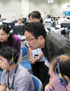 Associate Professor Wakabayashi (center) monitoring the experiment from the User Operations Area (UOA) at TKSC
