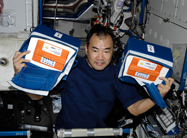 Astronaut Noguchi holding a sample bag containing the JAXA PCG protein samples
