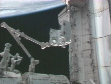 写真：ペイロードベイ（貨物室）への回収のため、ISSのロボットアーム（SSRMS）に把持される取外し可能型スペースラブパレット1（SLP-D1）