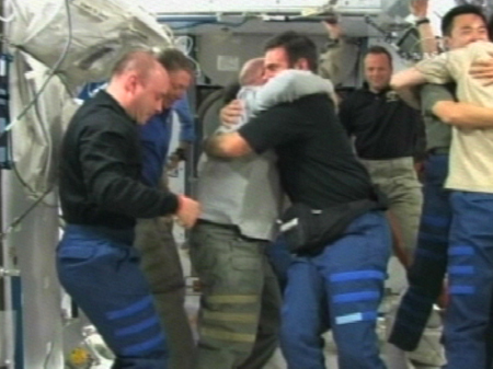 写真：別れの挨拶を交わすSTS-124クルーとISSの第17次長期滞在クルー（提供：NASA）