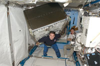 船内実験室へ米国の実験ラックを移設作業中のシャミトフ（中央）、ヴォルコフ（右）両宇宙飛行士（提供：NASA）