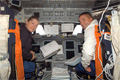 コックピットに座るパメラ・アン・メルロイ、ジョージ・ザムカ宇宙飛行士（飛行3日目）