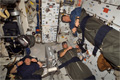 ディスカバリー号のミッドデッキにて寝袋の中で眠る（左から）パメラ・アン・メルロイ、ジョージ・ザムカ、パオロ・ネスポリ宇宙飛行士（飛行10日目）