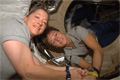 STS-120クルーが帰還のためISSから退室する際、与圧結合アダプタ（Pressurized Mating Adapter: PMA-2）内で握手をするパメラ・アン・メルロイ（左）、ペギー・ウィットソン両宇宙飛行士（右）（飛行13日目）