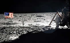 後ろ姿であるが月面上のアームストロング船長が写っている数少ない写真。星条旗と月着陸船と位置関係と船長の大きさに注目（提供NASA）