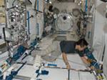 船内実験室で掃除機をかける若田宇宙飛行士
