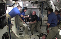 写真：ISSに入室し、ISS第27次長期滞在クルーに迎え入れられるエンデバー号のクルー