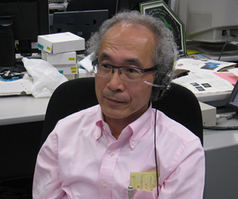 写真：実験運用管制室で実施の様子を見守る逢坂教授