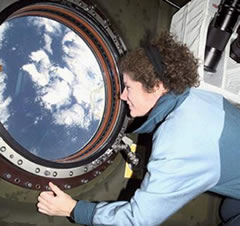 ISSディスティニー実験棟の窓から外を眺める第2次滞在クルーのヘルムズ宇宙飛行士