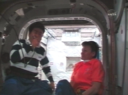 写真：船内保管室入室前に「きぼう」運用管制室と交信する土井宇宙飛行士（左）とペギー・ウィットソン宇宙飛行士（右）