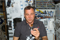 飲料の容器から液体の泡を絞り出すダフィッド（デイブ）・ウィリアムズ宇宙飛行士（飛行7日目）