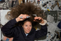 物資の移送作業に参加するため髪にブラシをかけるトレーシー・カードウェル宇宙飛行士（飛行10日目）